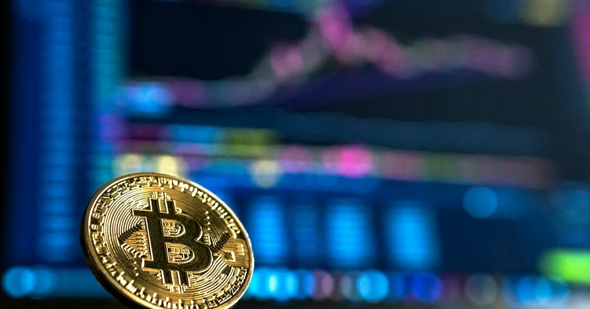 A gold-coloured bitcoin coin on a dark surface.