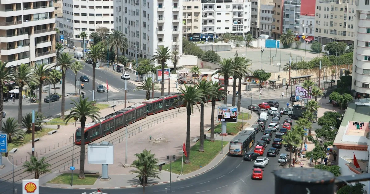 A Casablanca street with traffic running between tall buildings.